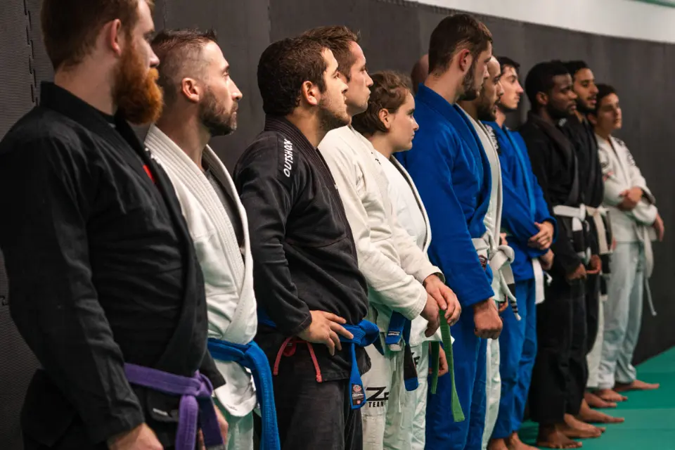 Combattants JJB alignés en rang sur un tatami vert